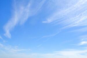 White feather clouds in bright azure sky as background with copy space photo