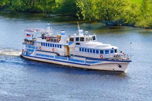 Aerial view on a small ship on the river a background of green trees on the shore photo