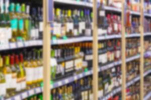 Blurred image of racks with alcoholic drinks in the store. Perspective view. photo