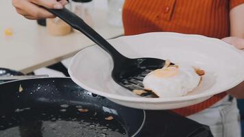 detail shot of a woman removing an egg from the frying pan with a spatula, preparing the typical colombian breakfast video