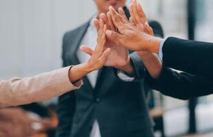 Motivated successful business team giving high five, happy young students employees group join hands with senior teacher mentor, team building unity concept, help support in teamwork, close up view photo