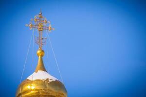 Gilded dome of a Christian temple a background of bright blue sky with copy space photo