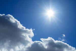 Close up view of a fluffy clouds and sun in deep blue sky photo