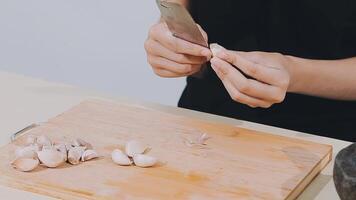 Woman using knife and hands cutting cucumber on wooden board in kitchen room. video