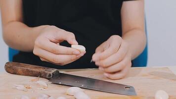Woman using knife and hands cutting cucumber on wooden board in kitchen room. video