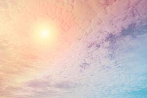 Abstract view on a fantastic soft clouds with pastel color and sun in the sky as background photo