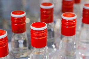 Row of a bottles of russian vodka in the store with red cover. Shallow depth of field photo