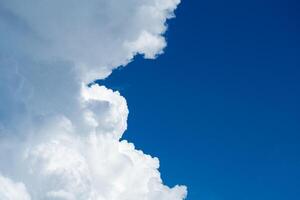 White cumulus fluffy clouds against a bright blue sky photo