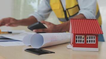 architect man working with laptop and blueprints,engineer inspection in workplace for architectural plan,sketching a construction project ,selective focus,Business concept vintage color video