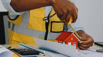architect man working with laptop and blueprints,engineer inspection in workplace for architectural plan,sketching a construction project ,selective focus,Business concept vintage color video