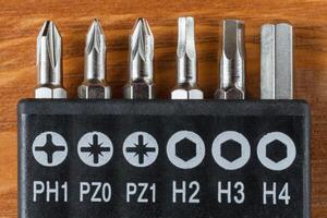 A set of tools collection from heads for screwdriver or bits on a wooden table photo