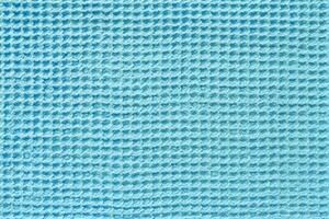 Close up view of a turquoise waffle fabric as background, texture photo