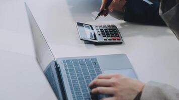 Young Asian businesswoman and businessman discuss investment project working and planning strategy on digital tablet. Business people talking together with tablet at office. video