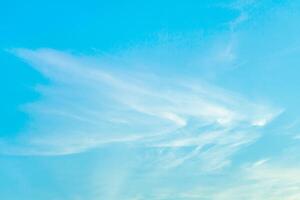 White cirrus clouds in bright turquoise sky as background photo