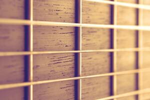 Close up view on a neck of acoustic guitar with strings illuminated by warm light photo