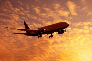 Dramatic view of a dark silhouette of aircraft against a orange clouds in the sunset sky photo