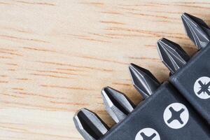 A set of tools collection from heads for screwdriver or bits on a wooden table photo