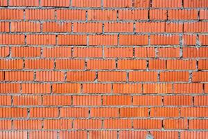 Wall of red brick with fluted texture as background, backdrop photo