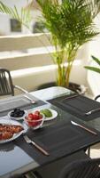 Dine outside with a table set on a patio, serving delicious food for a pleasant experience video