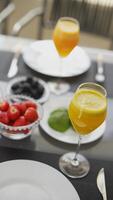 A variety of citrus drinks and fruits are elegantly presented on a table in an outdoor setting video