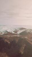 large snow patch left over on the volcanic rock field of a mountain in summer video