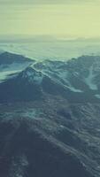 large snow patch left over on the volcanic rock field of a mountain in summer video