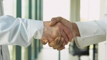 Two multiracial doctors shake hands with each other. The meeting of doctors embraced hands. Greetings from two doctors. Shake each other's hands. An office in a hospital shaking hands video