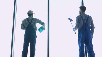 profesional limpieza equipo, dos multirracial hombres lavados ventana en oficina video