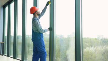 A repairman in uniform installs pvc windows in new office video