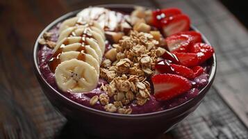 Acai bowl topped with granola, sliced bananas, strawberries, and a drizzle of honey. photo