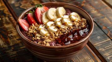 Acai bowl topped with granola, sliced bananas, strawberries, and a drizzle of honey. photo
