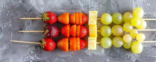 Colorful rainbow fruit skewers with strawberries, grapes, pineapple, and melon balls. photo
