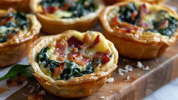 Mini quiches filled with spinach, bacon, and cheese, baked in a flaky pastry shell photo