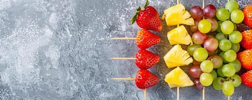 Colorful rainbow fruit skewers with strawberries, grapes, pineapple, and melon balls. photo