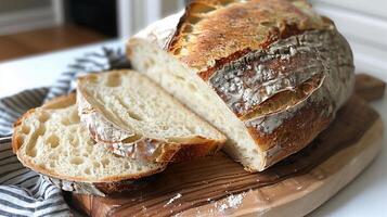Rustic sourdough bread loaf with a crispy crust, sliced and displayed on a cutting board. photo