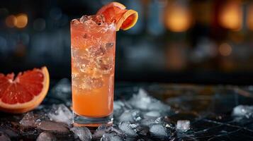 Tangy grapefruit juice served over ice in a highball glass with a grapefruit twist. photo