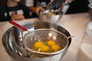 eggs in a bowl on the kitchen table for making a pie at a culinary master class photo
