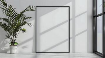 A minimalistic interior with a large blank picture frame leaning against a white wall. A potted plant is placed next to the frame, sunlight streams through a nearby window photo