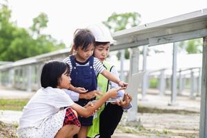 Mother and daughter on a solar farm filled with solar panels. Solar energy for future generations resource saving concept Electrical energy sources and alternative energy. photo