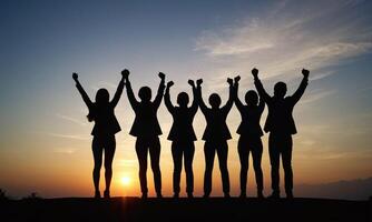 Silhouette of business team stand and feel happy on the most high at stand on sunset photo