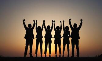 Silhouette of business team stand and feel happy on the most high at stand on sunset photo