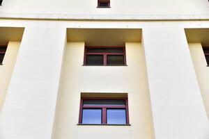 A red window on a yellow wall. A beautiful window in a classic building. photo