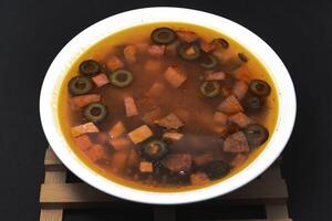 Meat solyanka. Meat soup in a white plate. photo