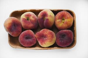 Flat peaches on a white background. Peaches in a package. photo