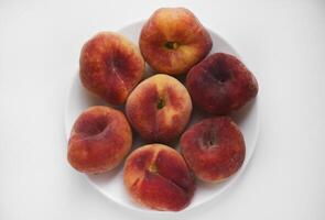 Flat peaches on a white background. Peaches in a package. photo