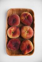Flat peaches on a white background. Peaches in a package. photo