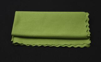 A green cleaning cloth on a black background. photo