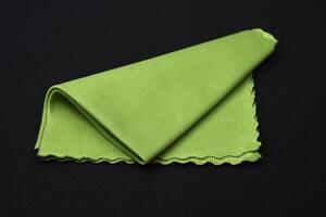 A green cleaning cloth on a black background. photo