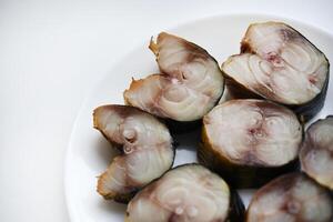 Sliced smoked Scomber on a white plate. Fish appetizer. photo