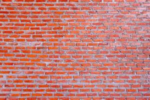Red brick wall background with uneven texture and varying brick sizes. photo